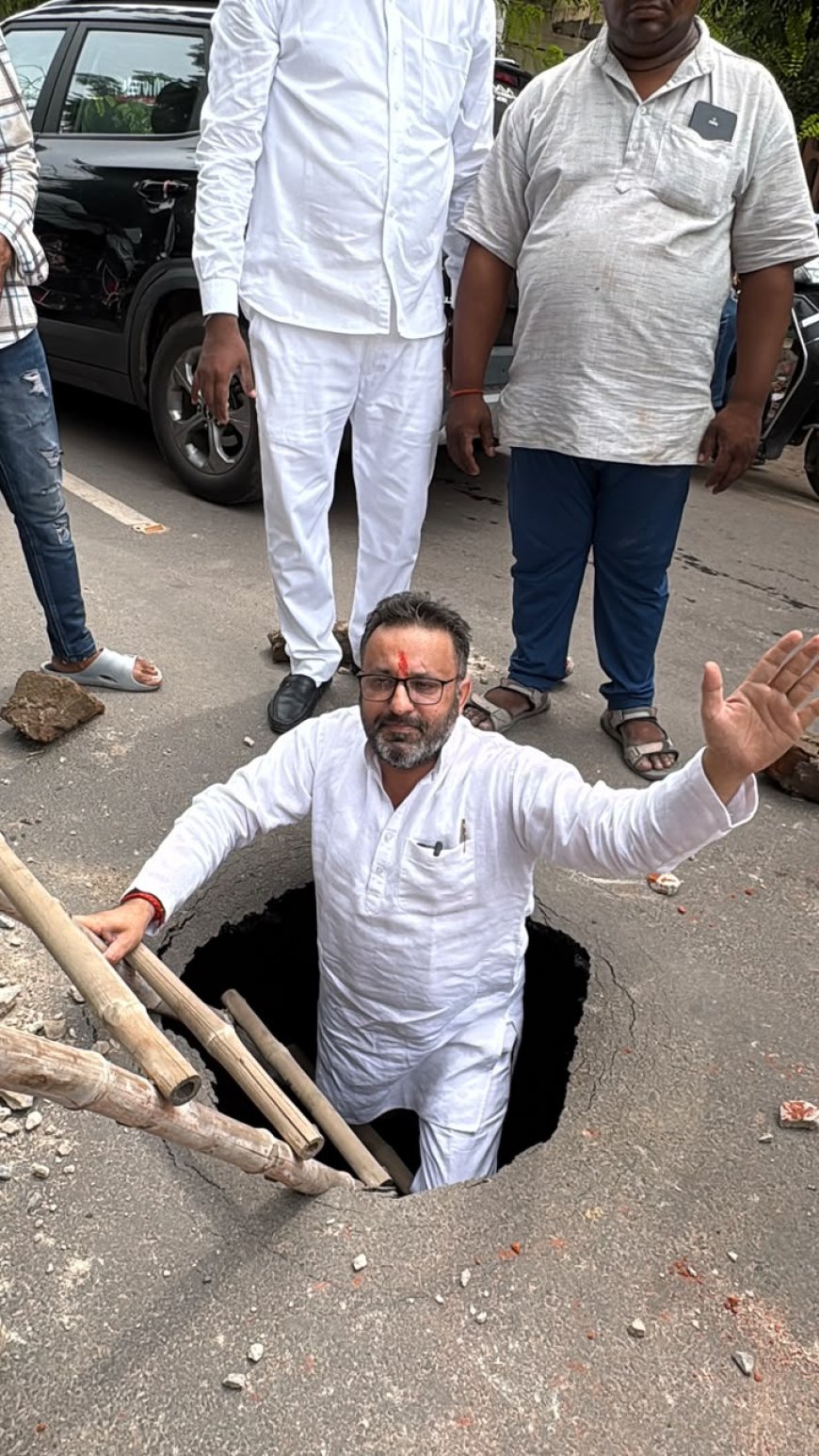 ‘यह सड़क है या पाताल लोक का रास्ता’, कमला नगर के गड्ढे में सीढ़ी लगाकर उतरे सपा नेता
